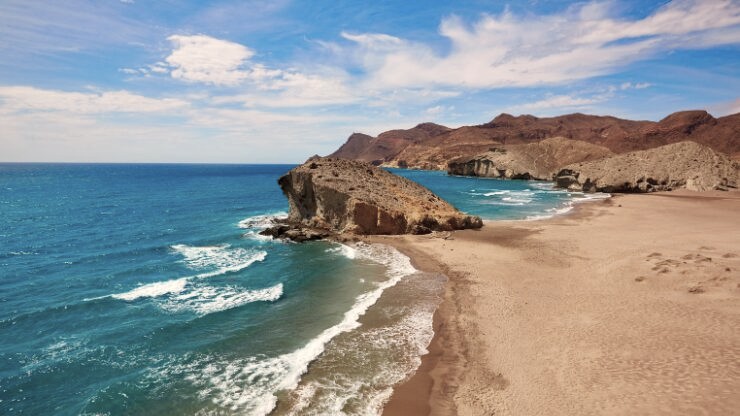Strand in Andalusië met helderblauw water en rotsen