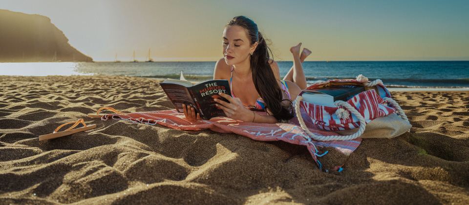 Jeune fille lisant un livre en bord de plage