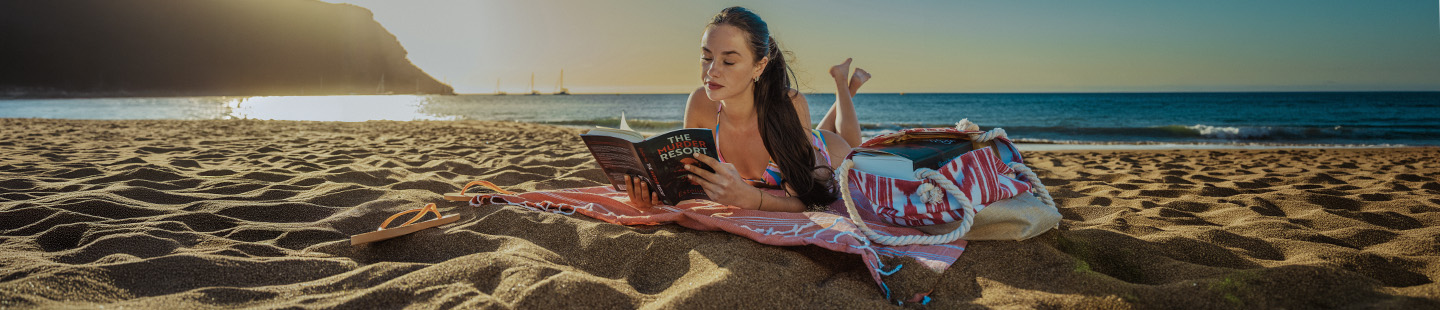 Jeune fille lisant un livre en bord de plage