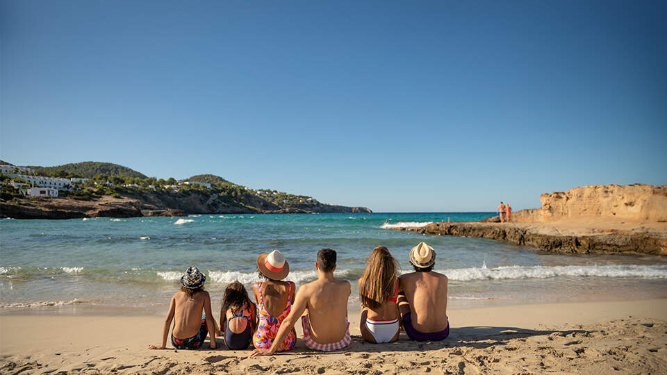 Famille heureuse assise en bord de plage