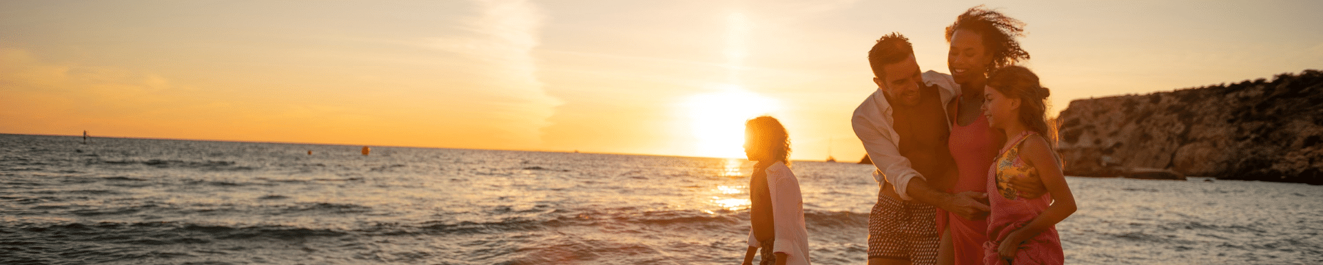 Famille en bord de mer lors d'un coucher de soleil