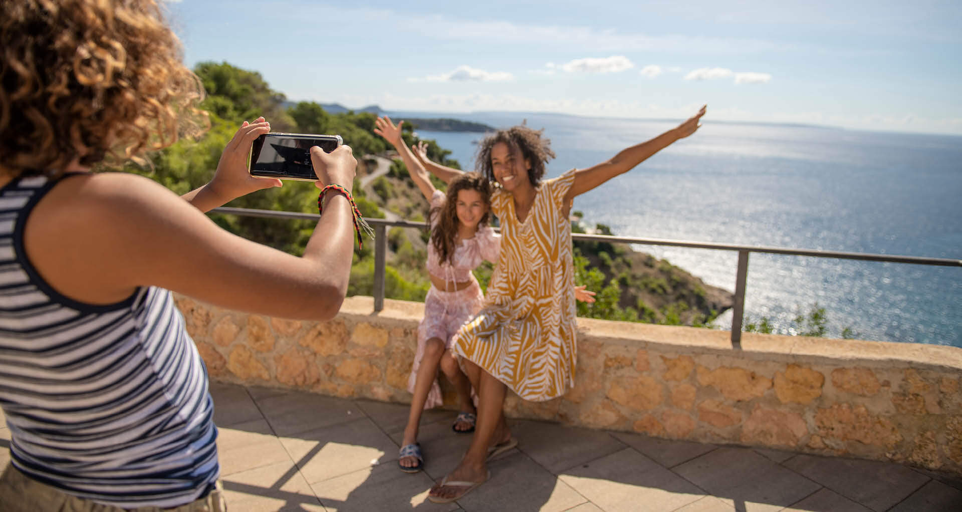 Une femme prenant en photo une mère et sa fille lors de vacances au soleil