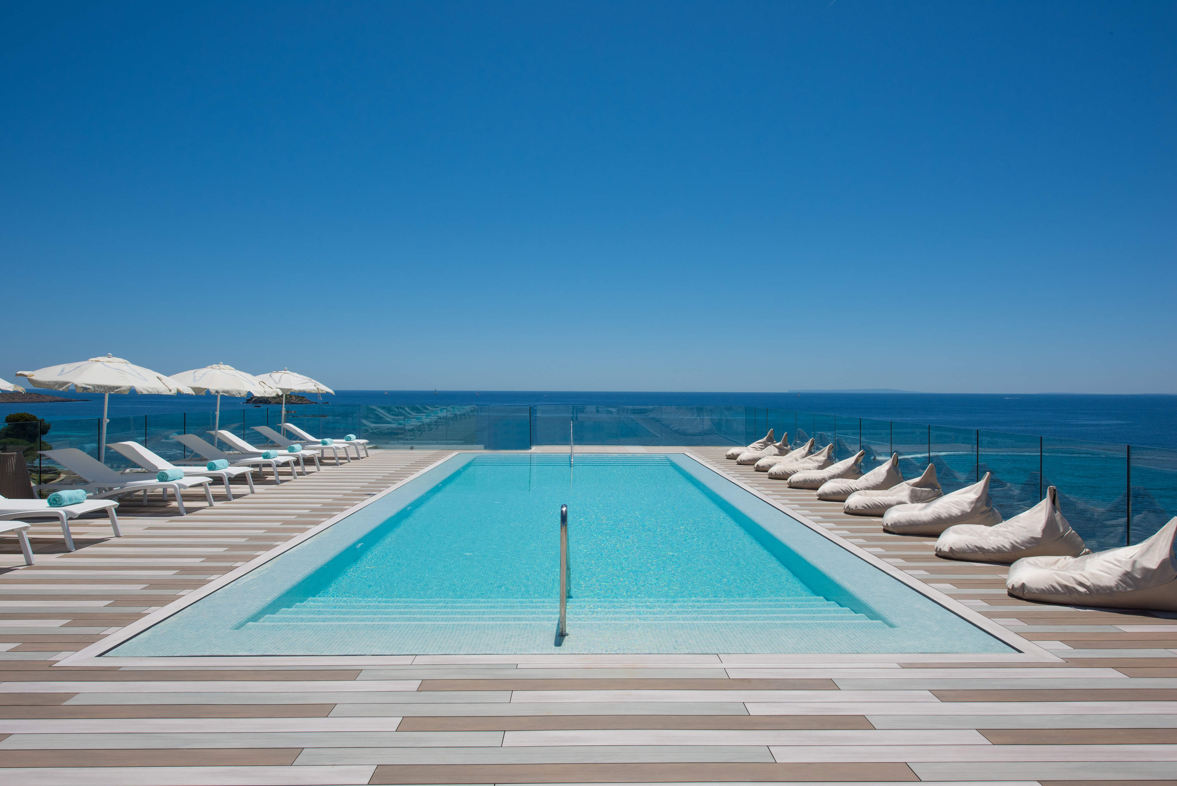 Piscine entourée de transats donnant sur mer, hôtel Iberostar Espagne