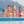 Famille dans grande piscine à débordement, avec falaises en arrière plan