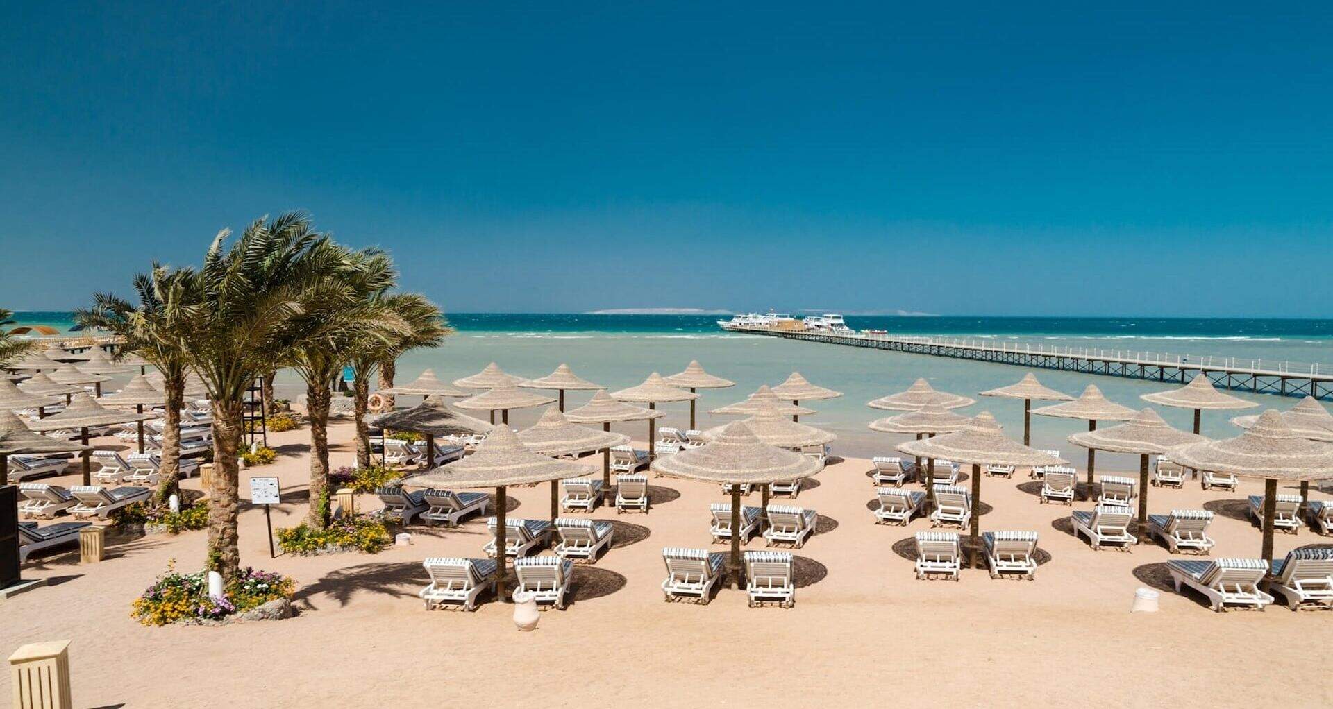 Plage de sable fin, parasols, transats et palmiers, Hurghada, Egypte