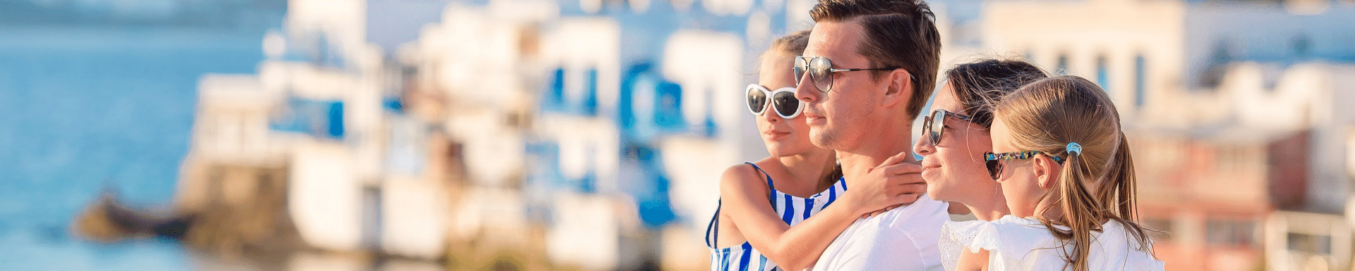 Famille qui contemple l'horizon avec paysage typique blanc et bleu grec en arrière plan, Grèce