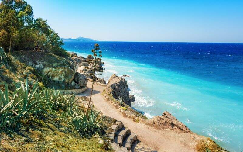 Une plage rocheuse avec de la verdure sur l'île de Rhodes, en Grèce