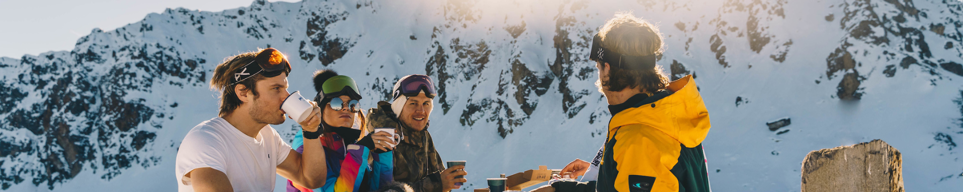 Un groupe d'amis buvant un verre à proximité des montagnes enneigées
