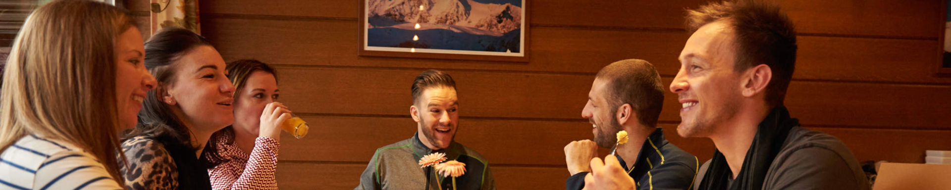 Un groupe d'amis profitant d'un dîner ensemble lors de leur séjour au ski en hébergement seul