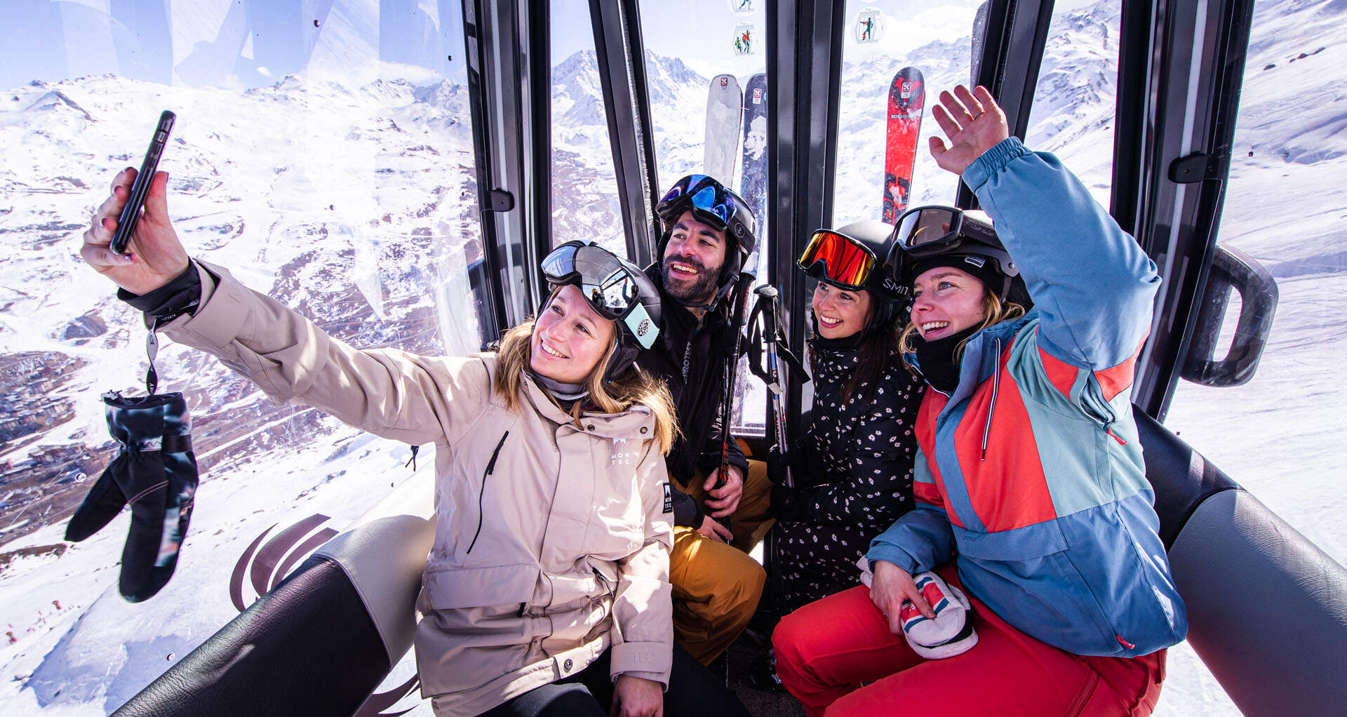 groep wintersporters in skilift maken selfie met mobiel