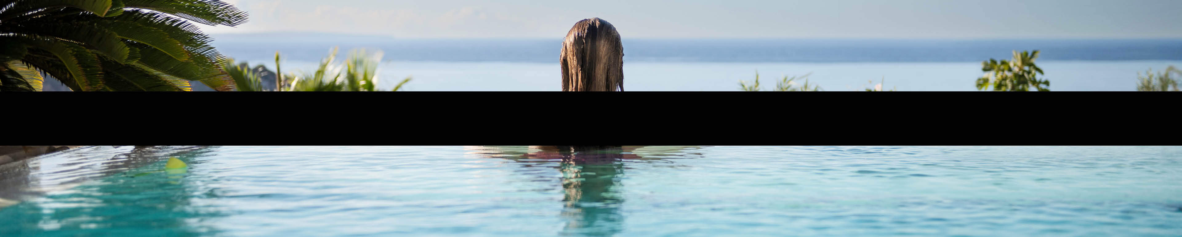 Black Friday  - vrouw kijkt vanaf rand infinity pool naar de zee