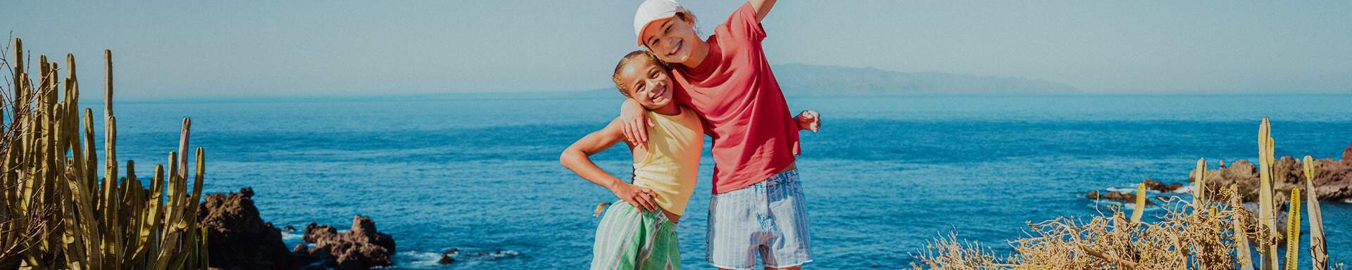 Twee kinderen knuffelend voor de zee