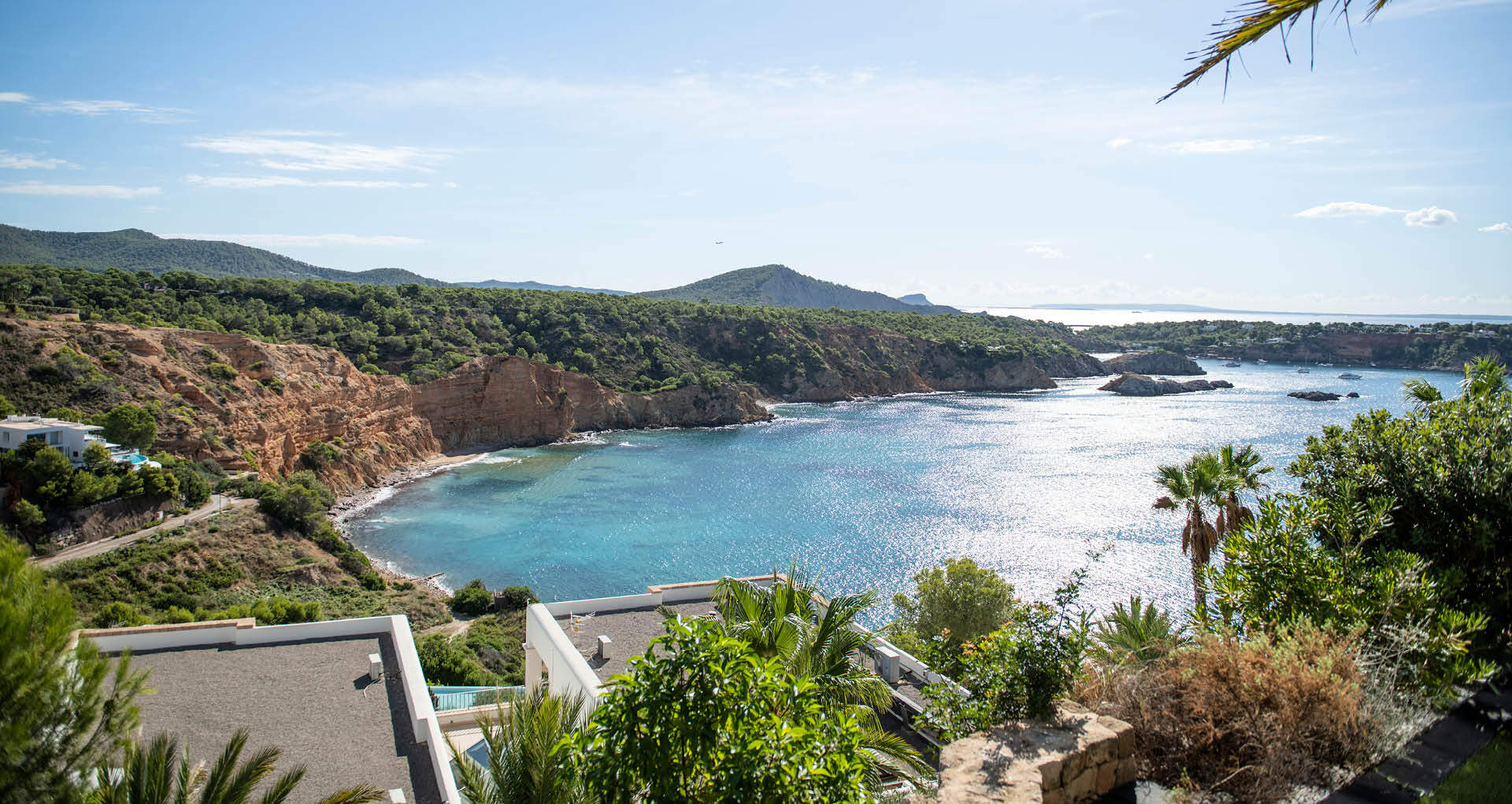 Uitzicht over een baai met helderblauwe zee en groene bergen