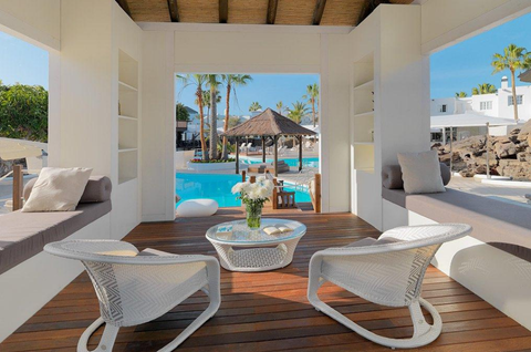 Twee stoelen met een klein tafeltje en met uitzicht over het zwembad