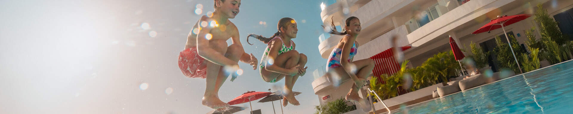 kinderen springen in het zwembad