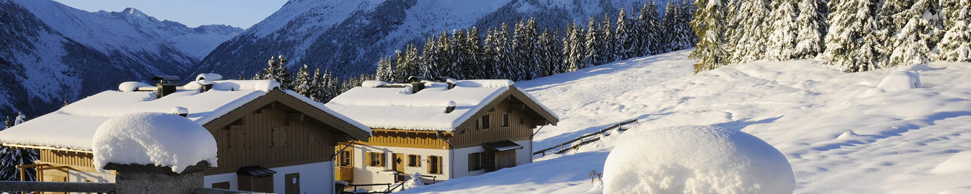 Twee huizen in de sneeuw, in een dal tussen de bergen van Gerlos