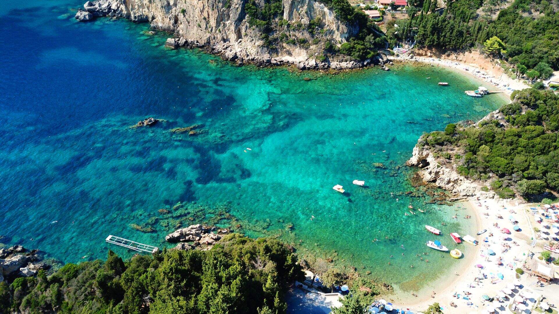 Baai met helder zeewater in Corfu met zandstrand en rotsen