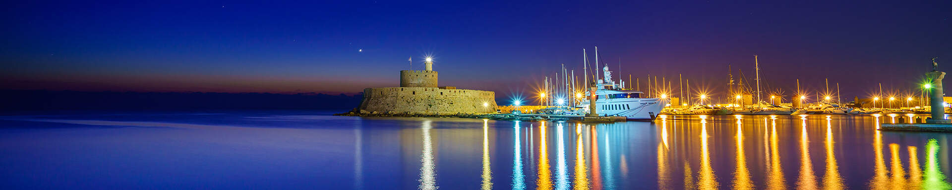 De haven van Rhodos verlicht in de avond