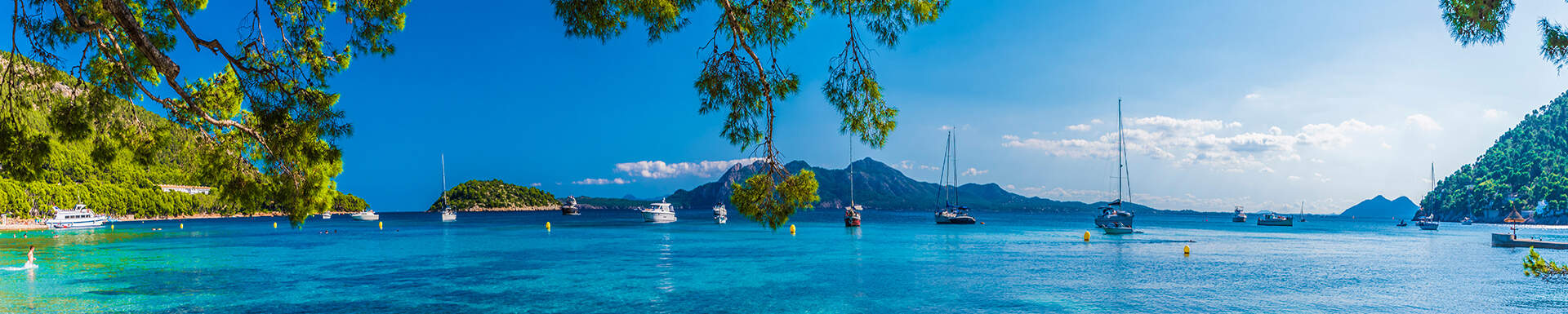 uitzicht op zee met bootjes omgeven door groen tijdens zomerse dag op mallorca spanje