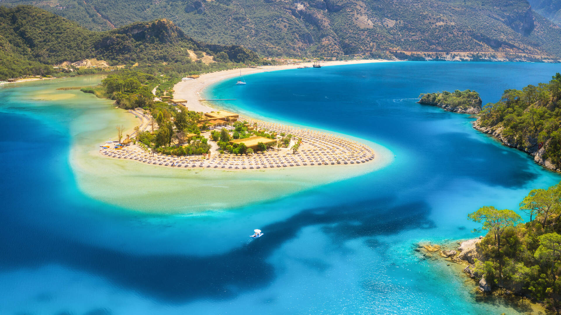 Prachtig eiland in Turkije in de azuurblauwe zee met ligbedjes