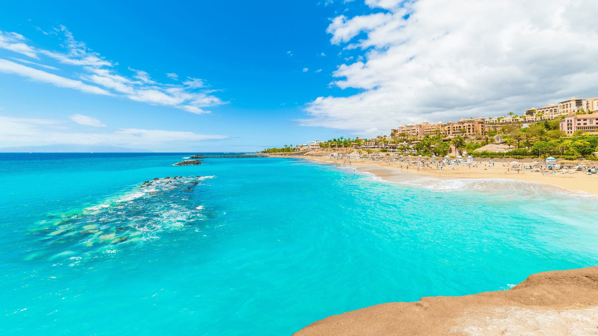 Een helderblauwe zee met zon en strand in Spanje